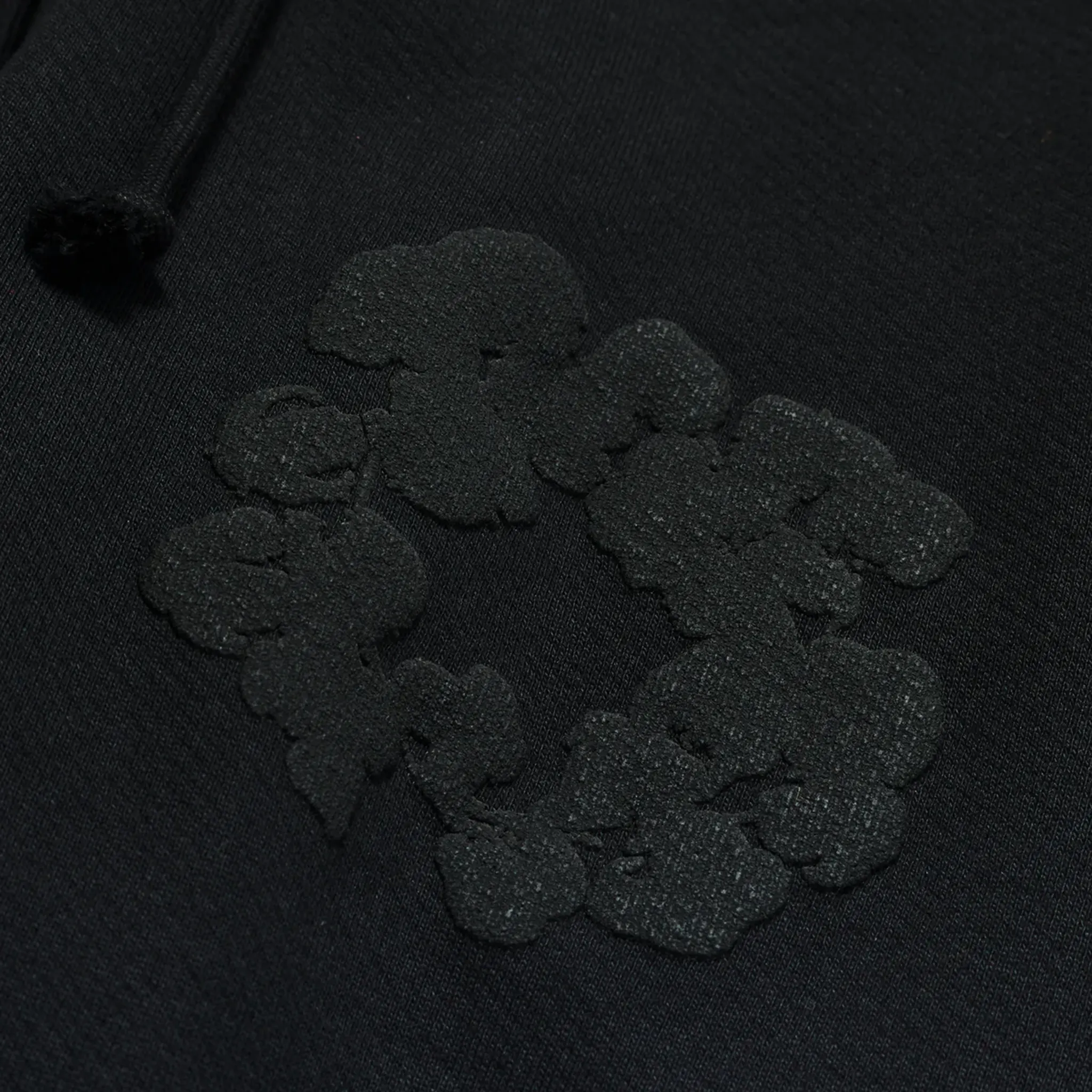 Detail view of Denim Tears Cotton Wreath Black Monochrome Sweatpants 5650 1SS240204CWSP BLAC