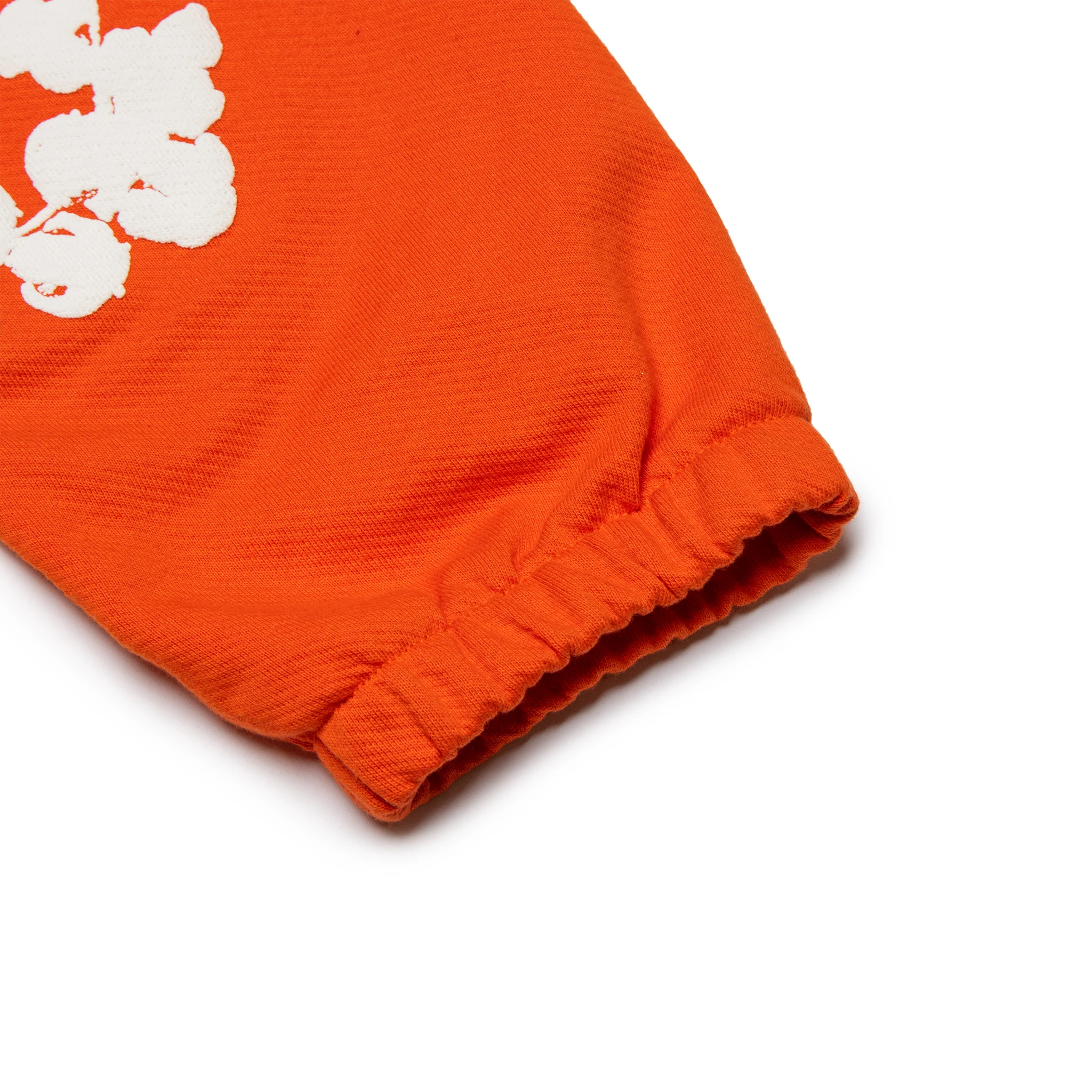 Leg view of Denim Tears The Cotton Wreath Orange Sweatpants