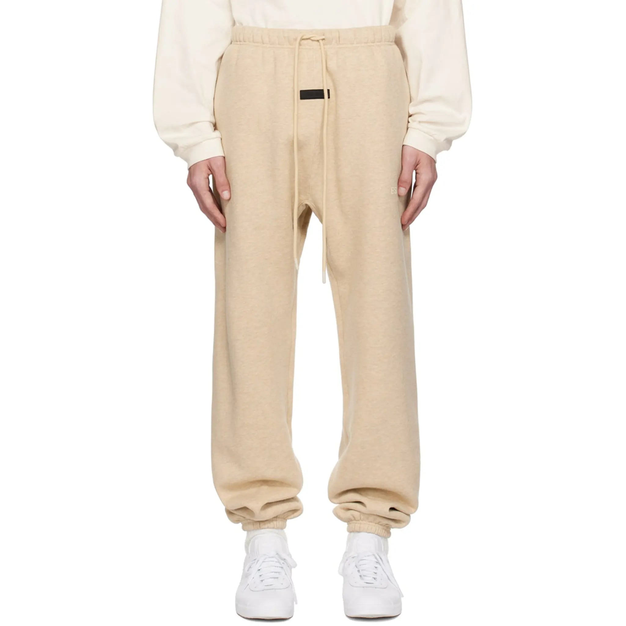 Model fromt view of Fear Of God Essentials Gold Heather Sweatpants (FW23)