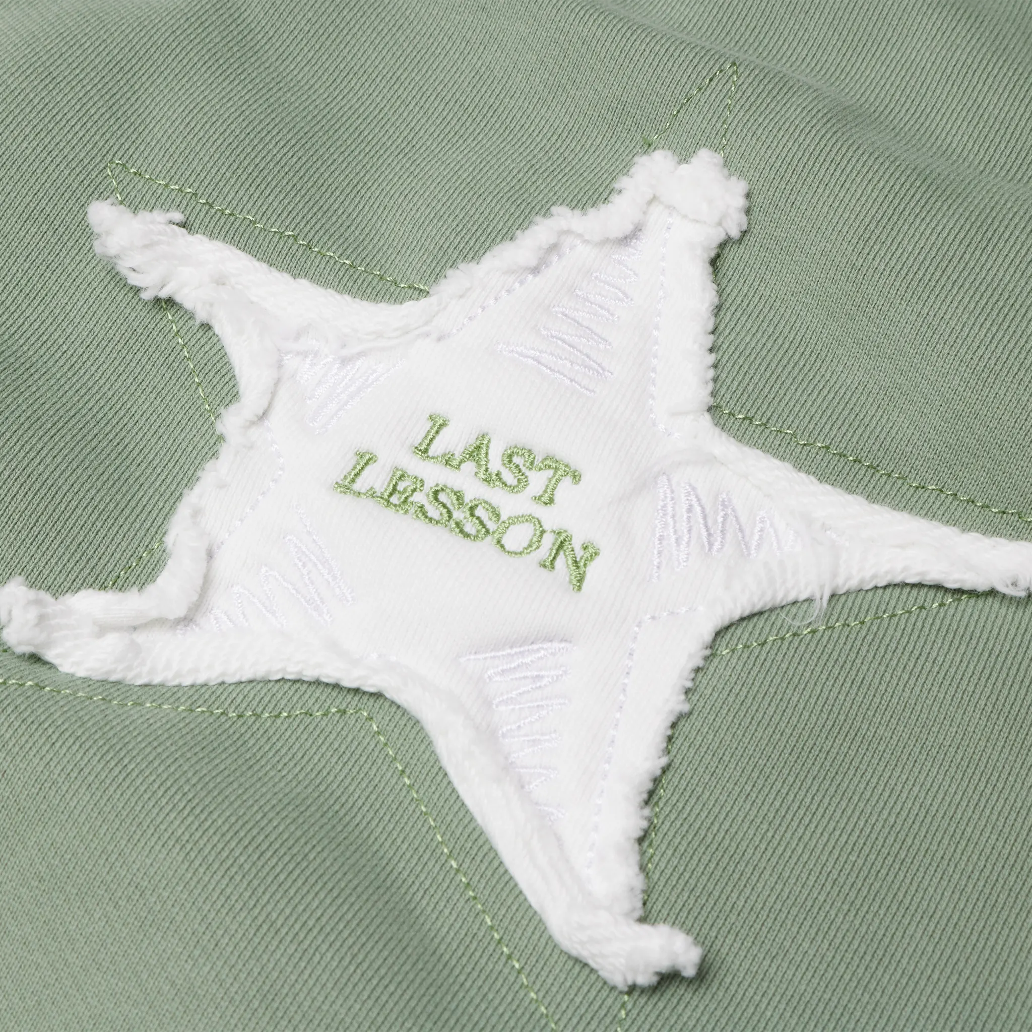 Detailed Logo View of Last Lesson Washed Applique Green Joggers