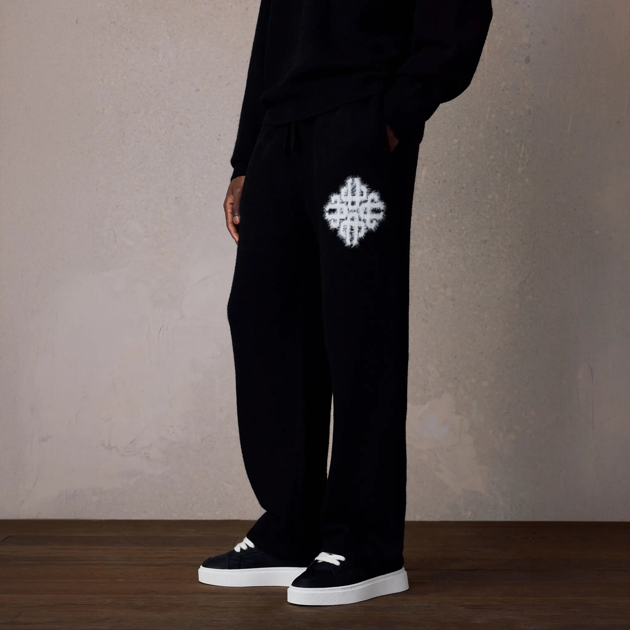 Front Side View of The Couture Club Emblem Fluffy Knit Black Sweatpants