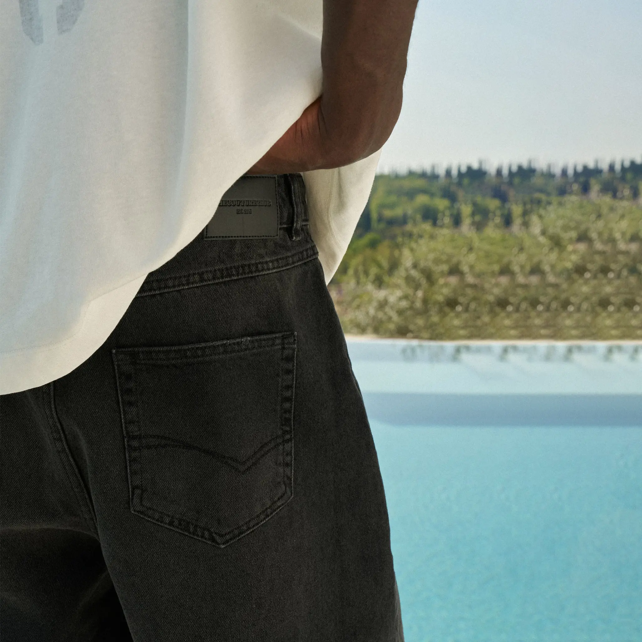 Back Side View of The Couture Club Raw Edge Washed Black Denim Shorts