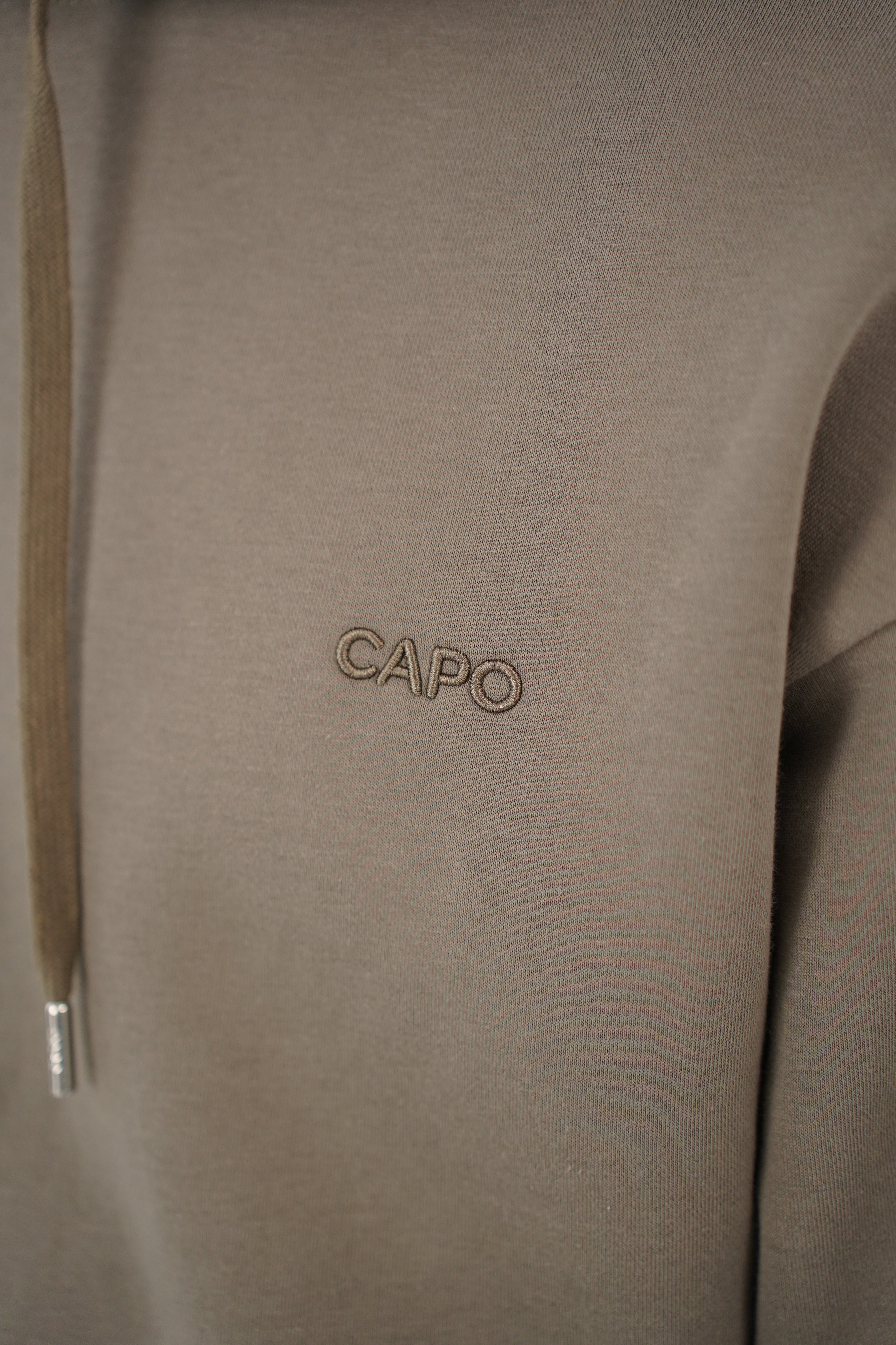 Logo detail view of CAPO Tracksuit Overhead Olive Hoodie