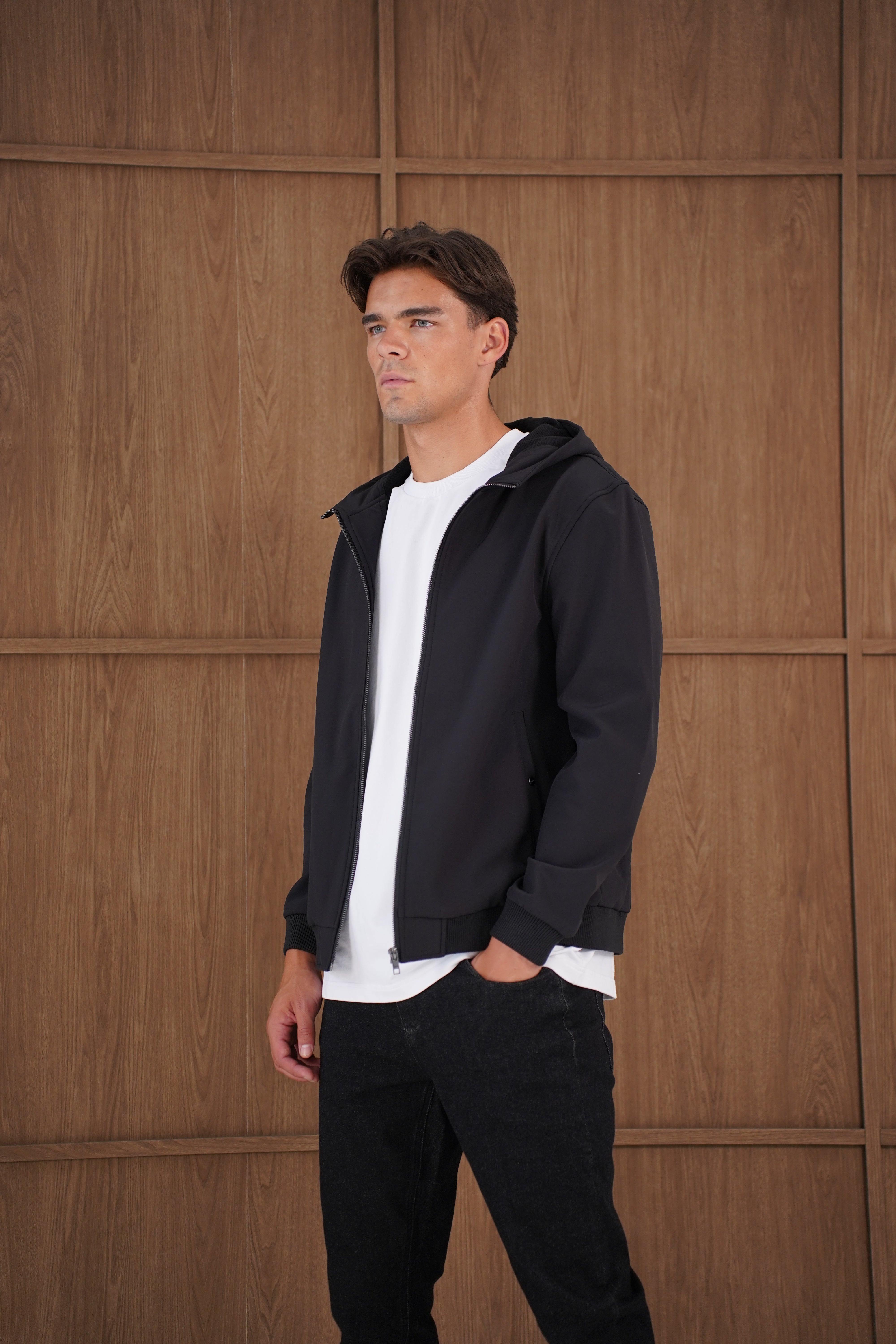 Model side view of CAPO Soft Shell Hood Black Jacket