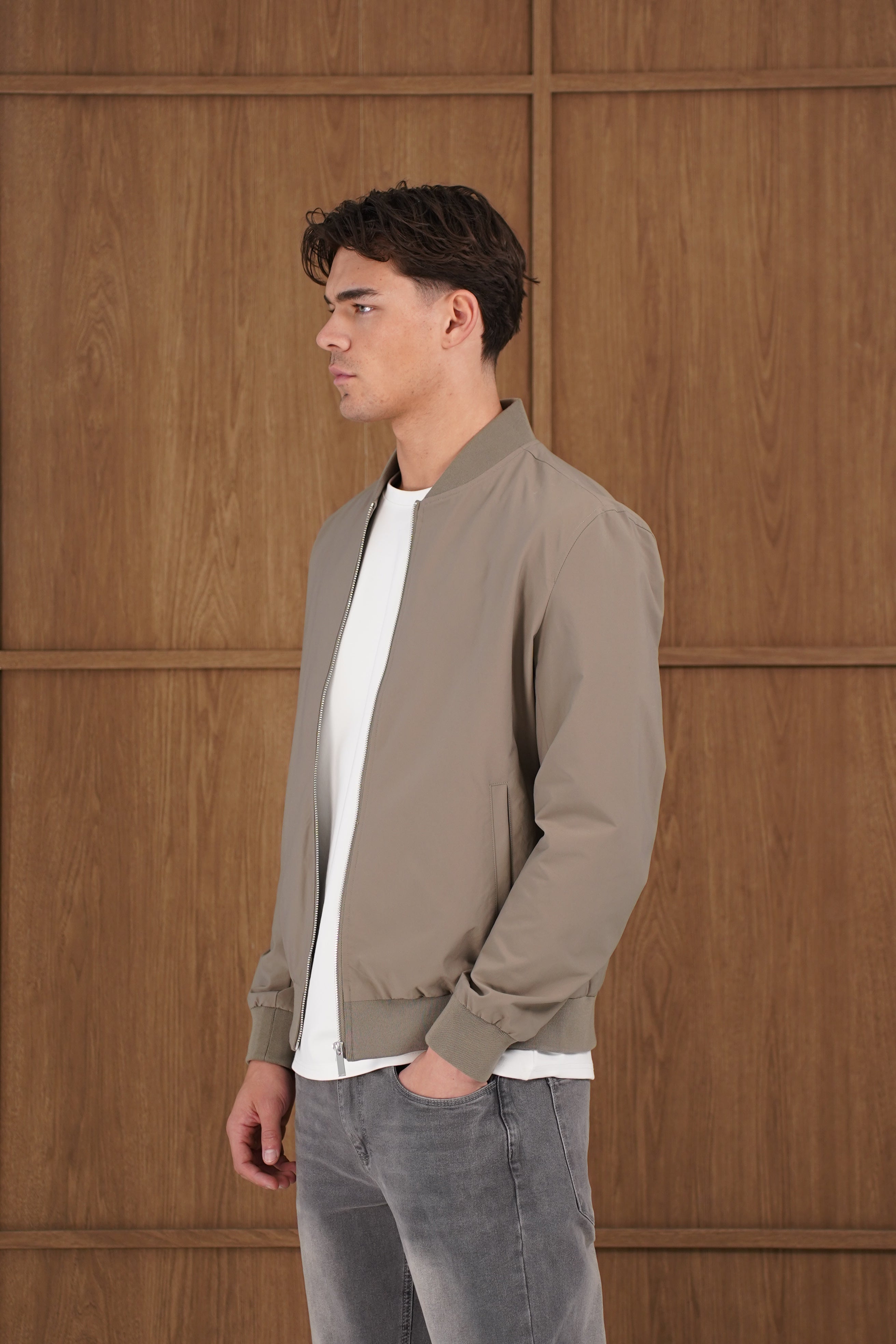 Model side view of CAPO Light Olive Bomber Jacket