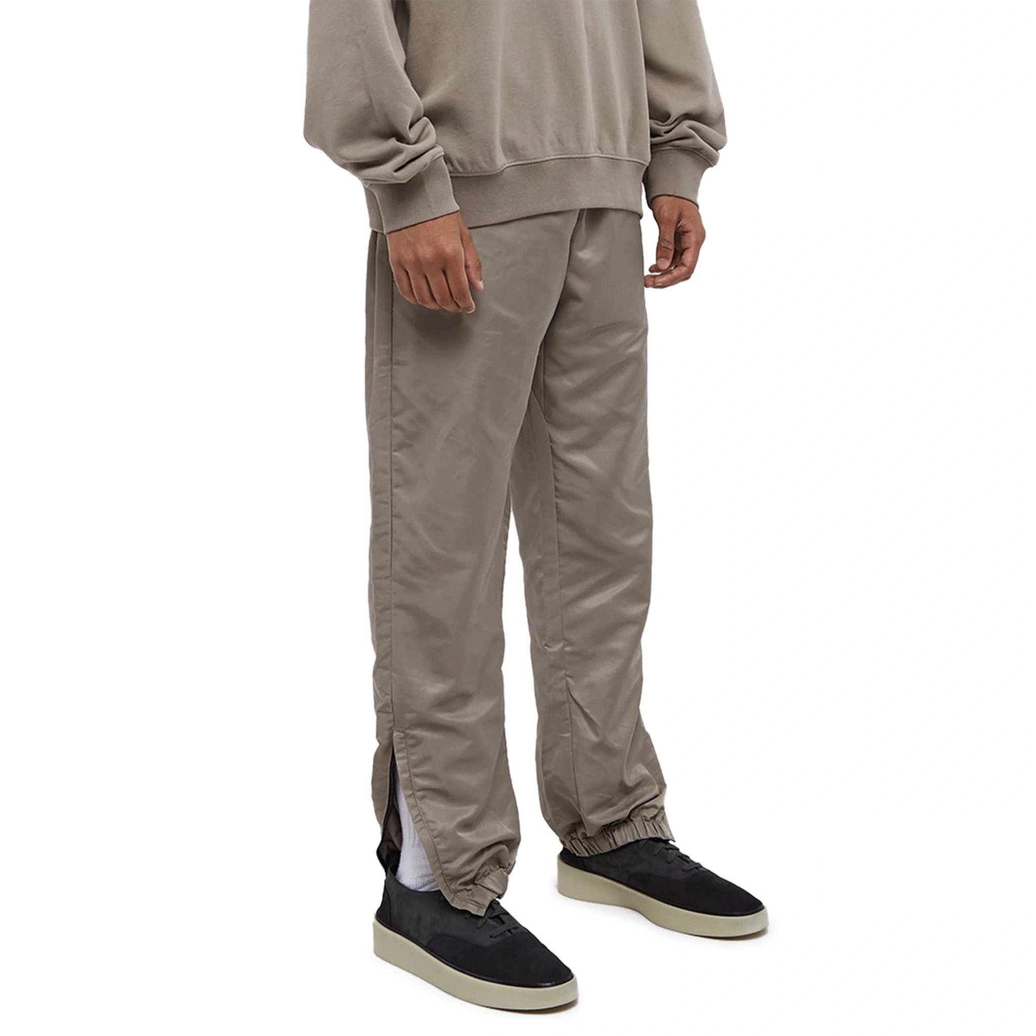 Model side view of Fear Of God Essentials Desert Taupe Track Pants (FW23) 130BT212161F