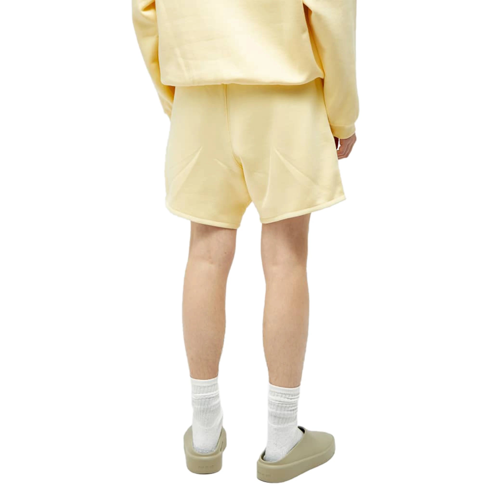 Model back view of Fear Of God Essentials Garden Yellow Shorts (FW23) 125SP244191F