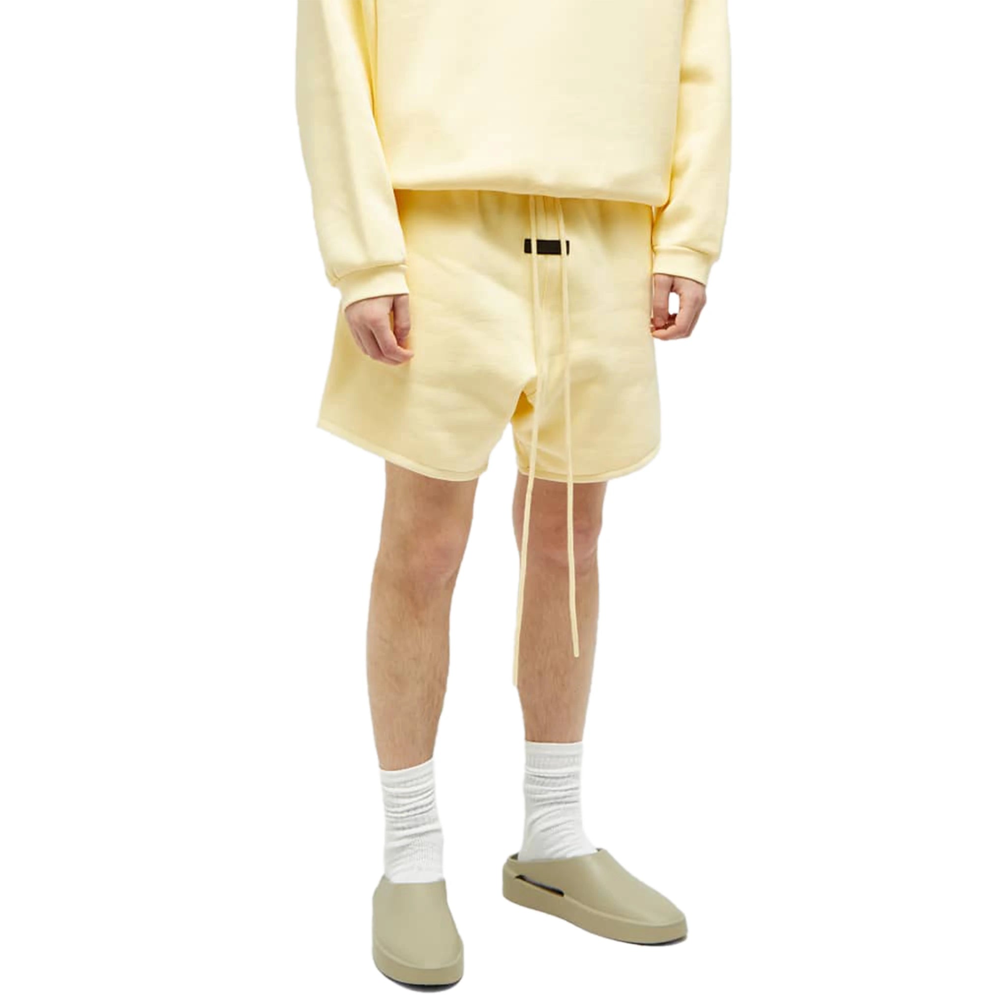 Model fromt view of Fear Of God Essentials Garden Yellow Shorts (FW23) 125SP244191F