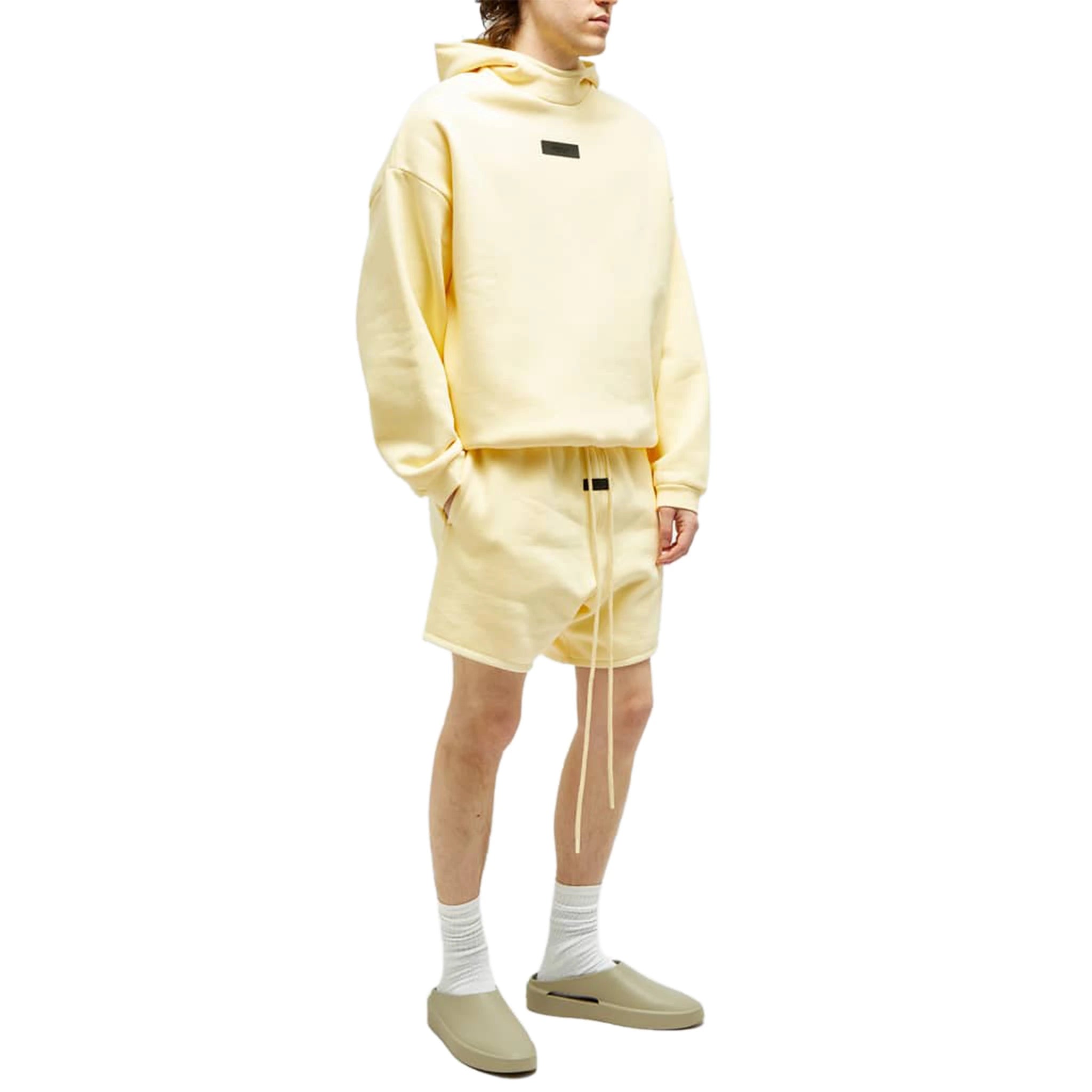 Model view of Fear Of God Essentials Garden Yellow Shorts (FW23) 125SP244191F