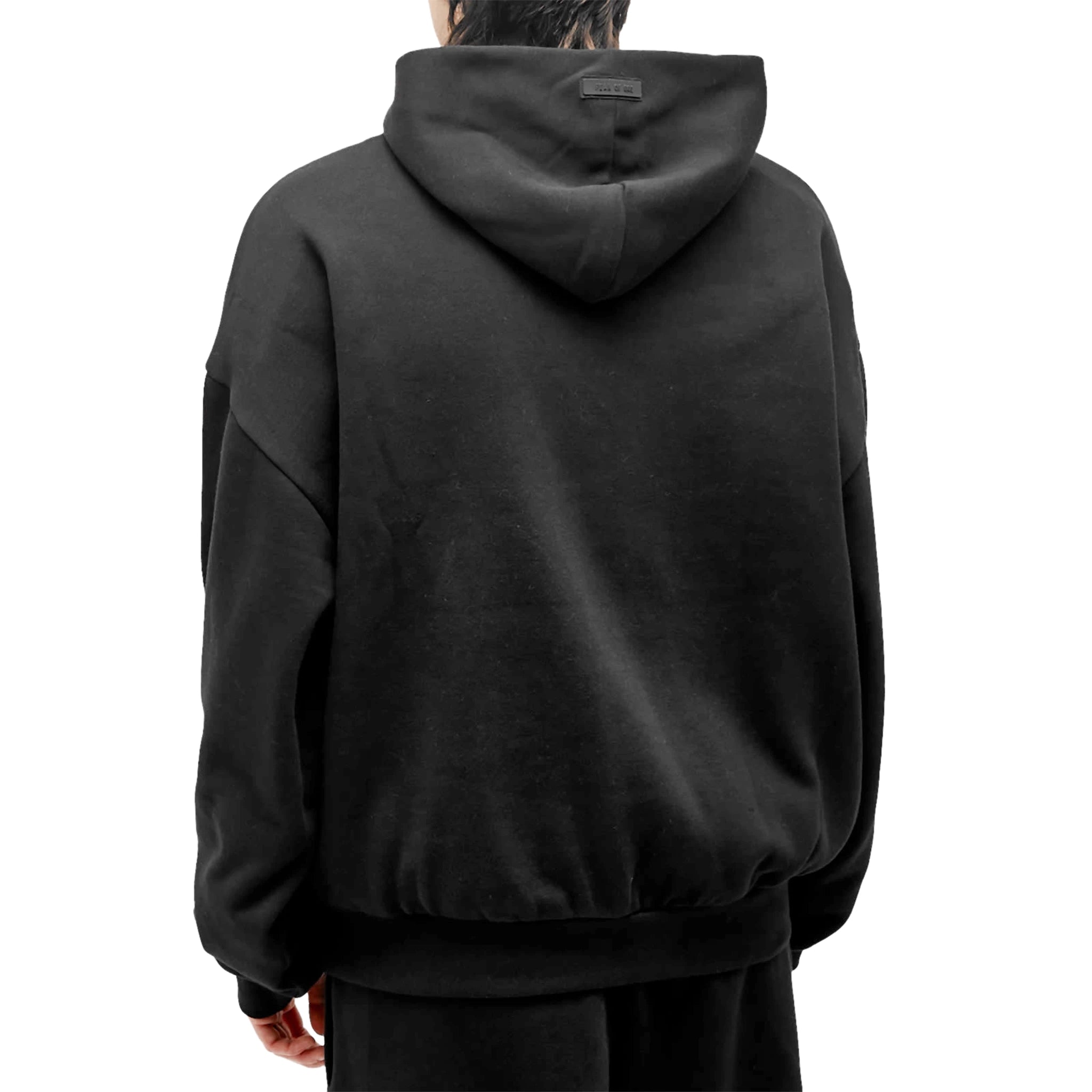 Model back view of Fear Of God Essentials Jet Black Hoodie (FW23)