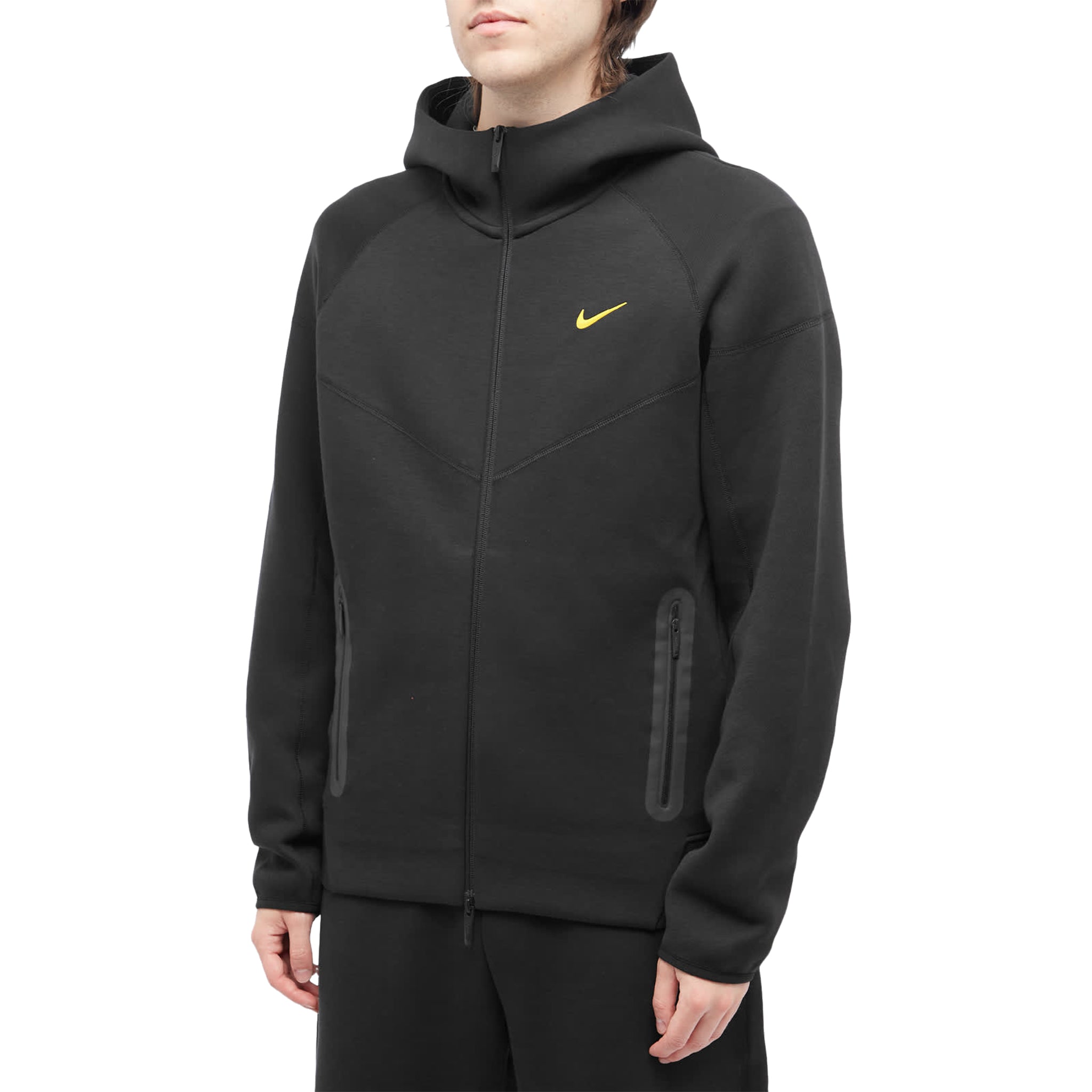 Model side view of nike x nocta tech fleece black zip-up hoodie fd8453-010